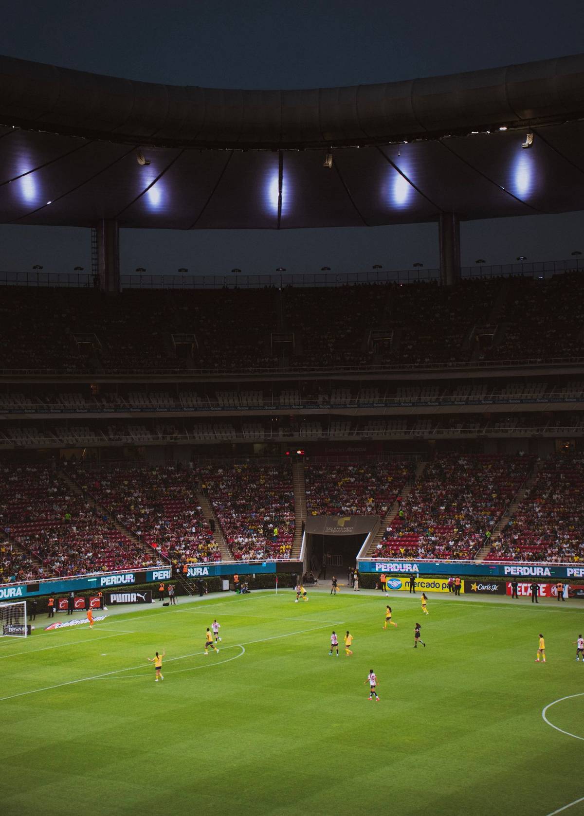 Pertandingan sepak bola malam hari di stadion
