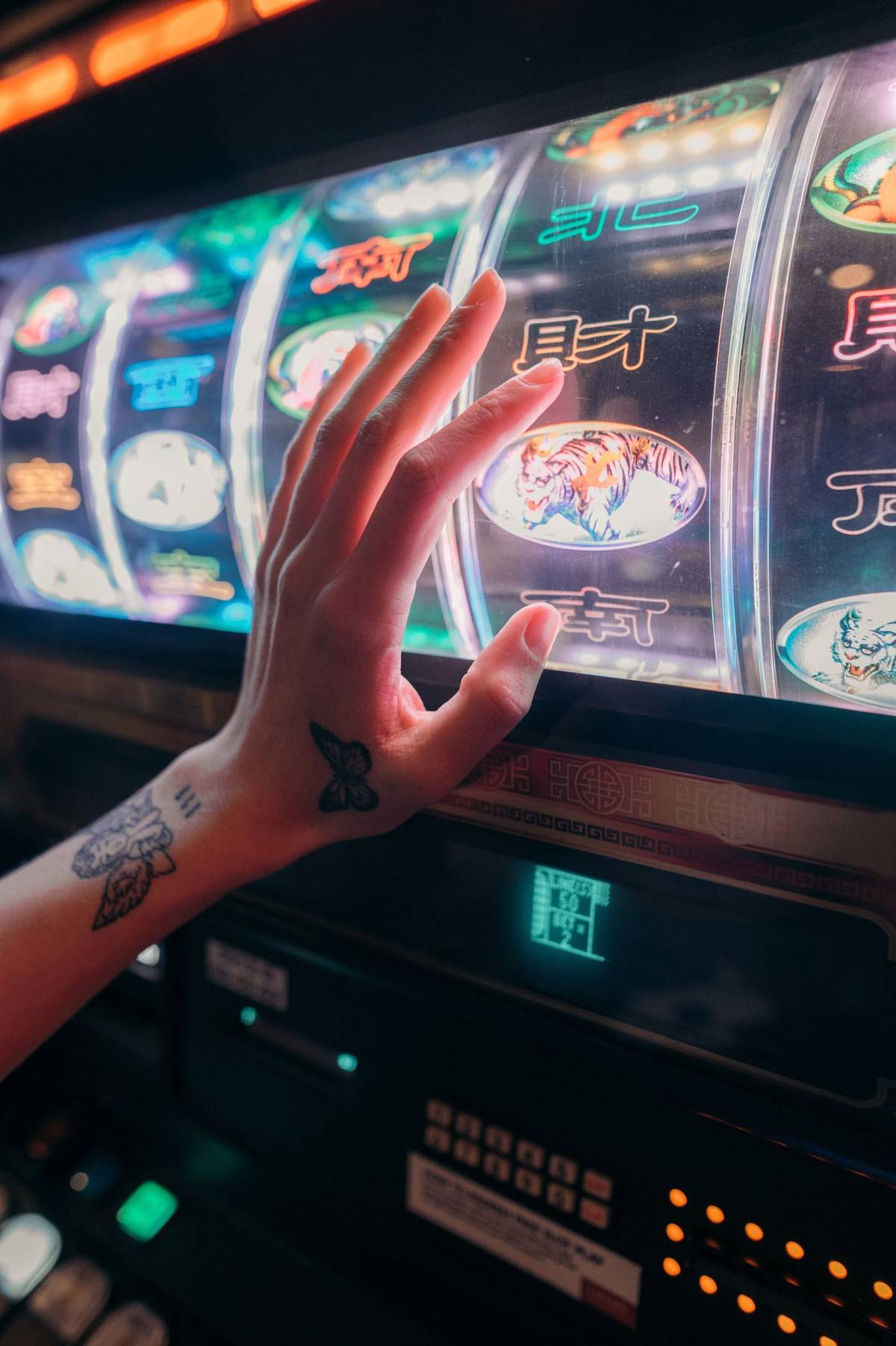 Tangan pemain di depan layar mesin slot