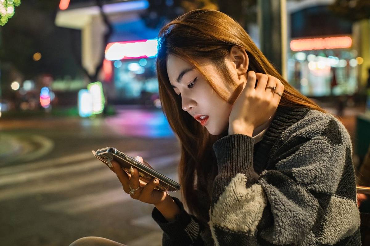 Pengguna menelusuri ponselnya pada malam hari